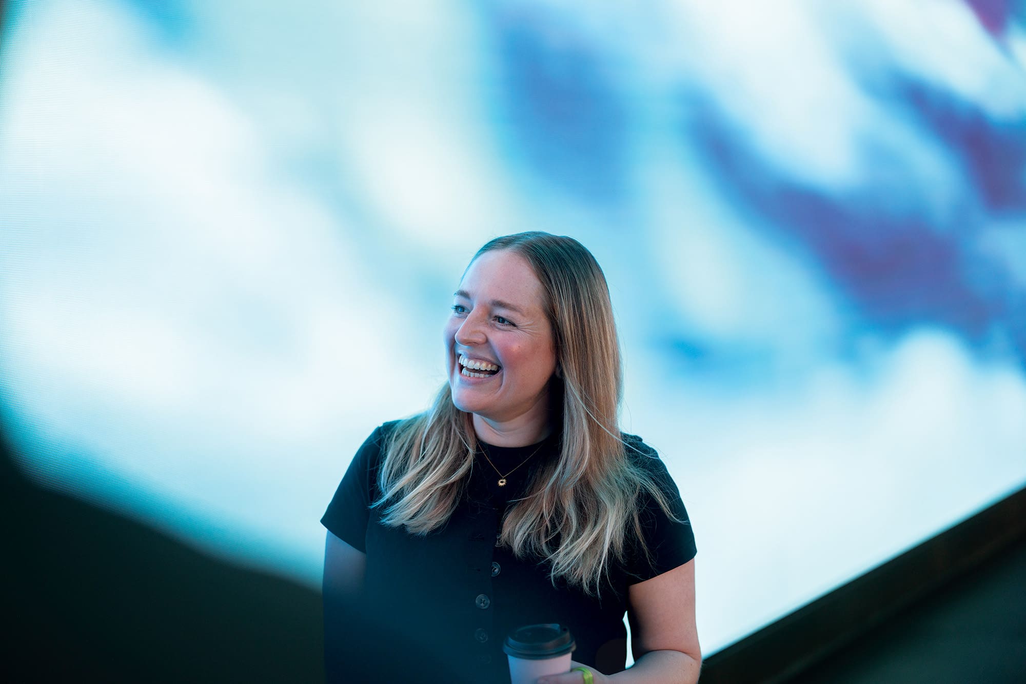 Woman smiling in front of a digital wall