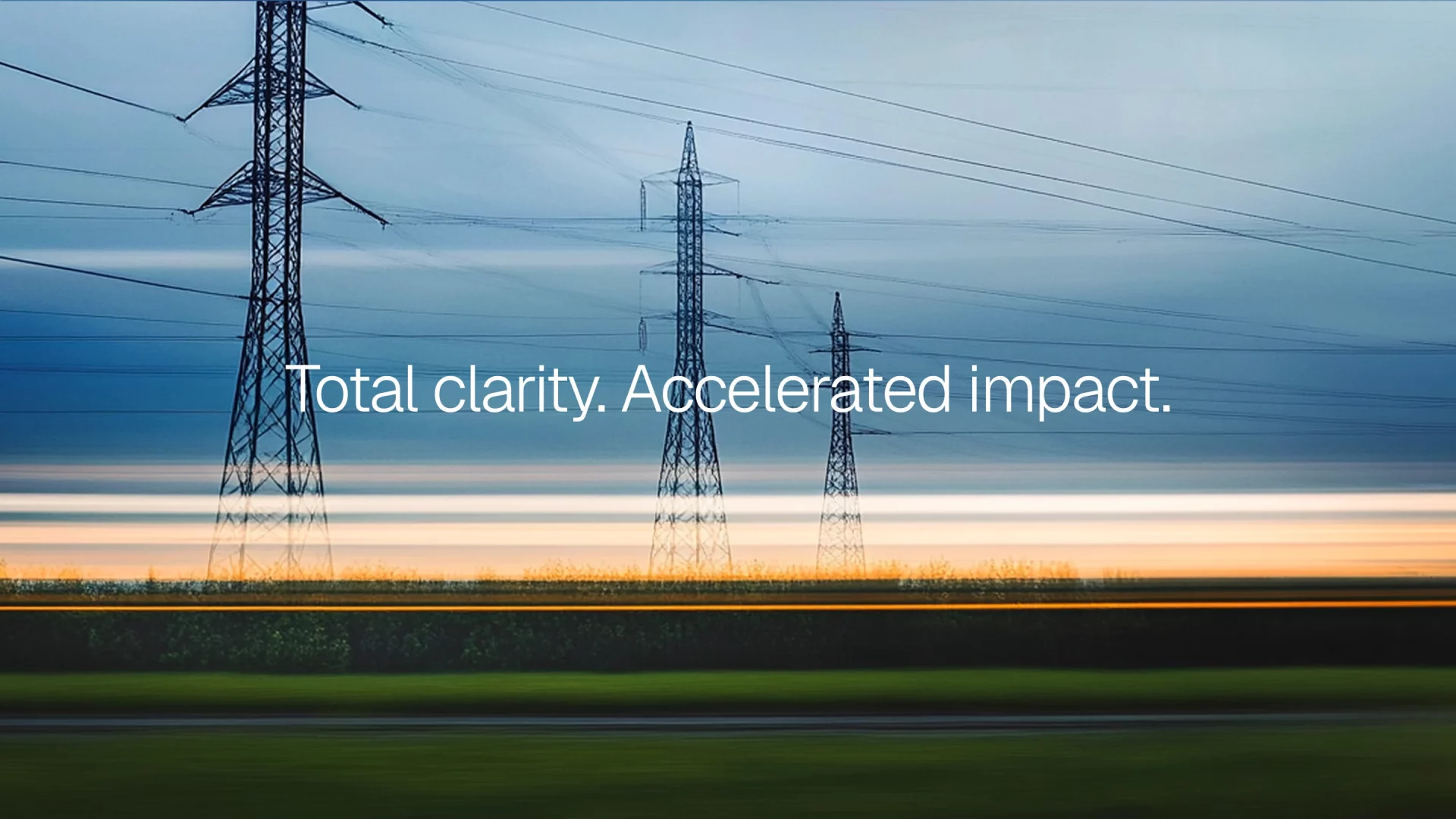 A landscape photograph of high-voltage electricity transmission towers stretching across the horizon beneath a cloudy blue sky at dusk. White text overlaid on the image reads, "Total clarity. Accelerated impact." A streak of motion blur near the bottom suggests a passing vehicle or long-exposure effect.