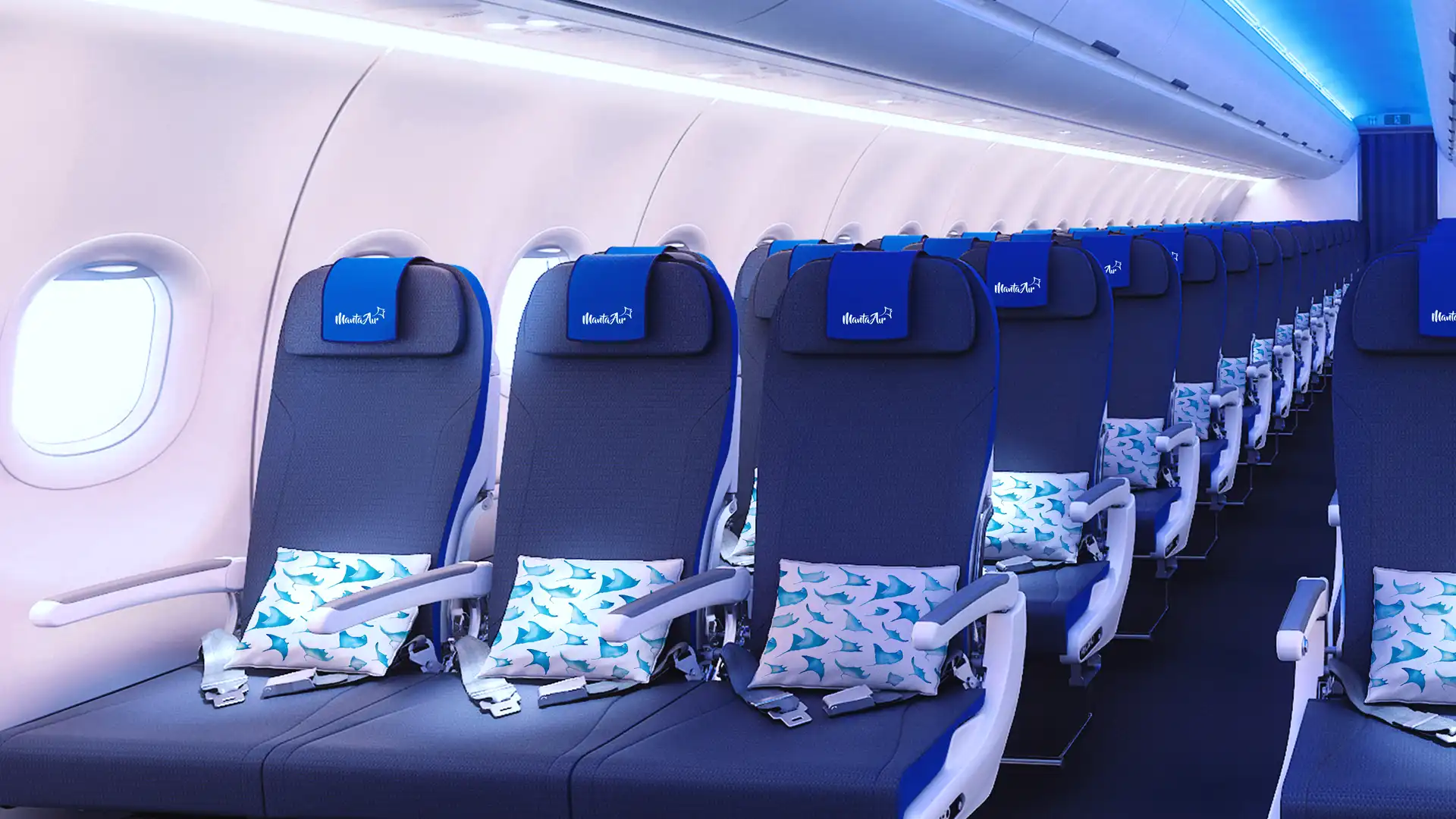 The interior of a Manta Air passenger cabin featuring rows of blue upholstered seats with branded headrest covers and decorative cushions patterned with manta rays. Soft blue ambient lighting, large windows, and a clean, modern design create a bright and comfortable atmosphere.