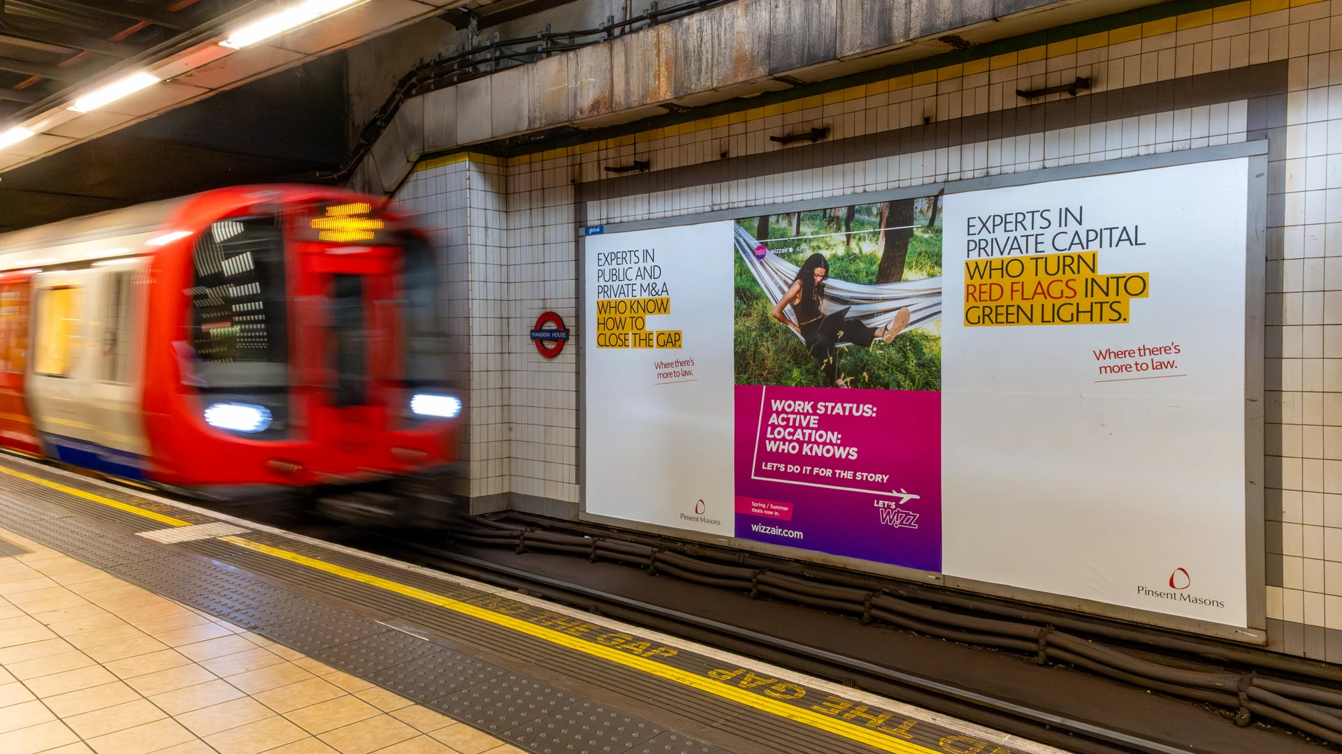 A Tube train passes Pinsent Masons posters at Mansion House station, promoting M&A expertise and private capital experts “who turn red flags into green lights.”