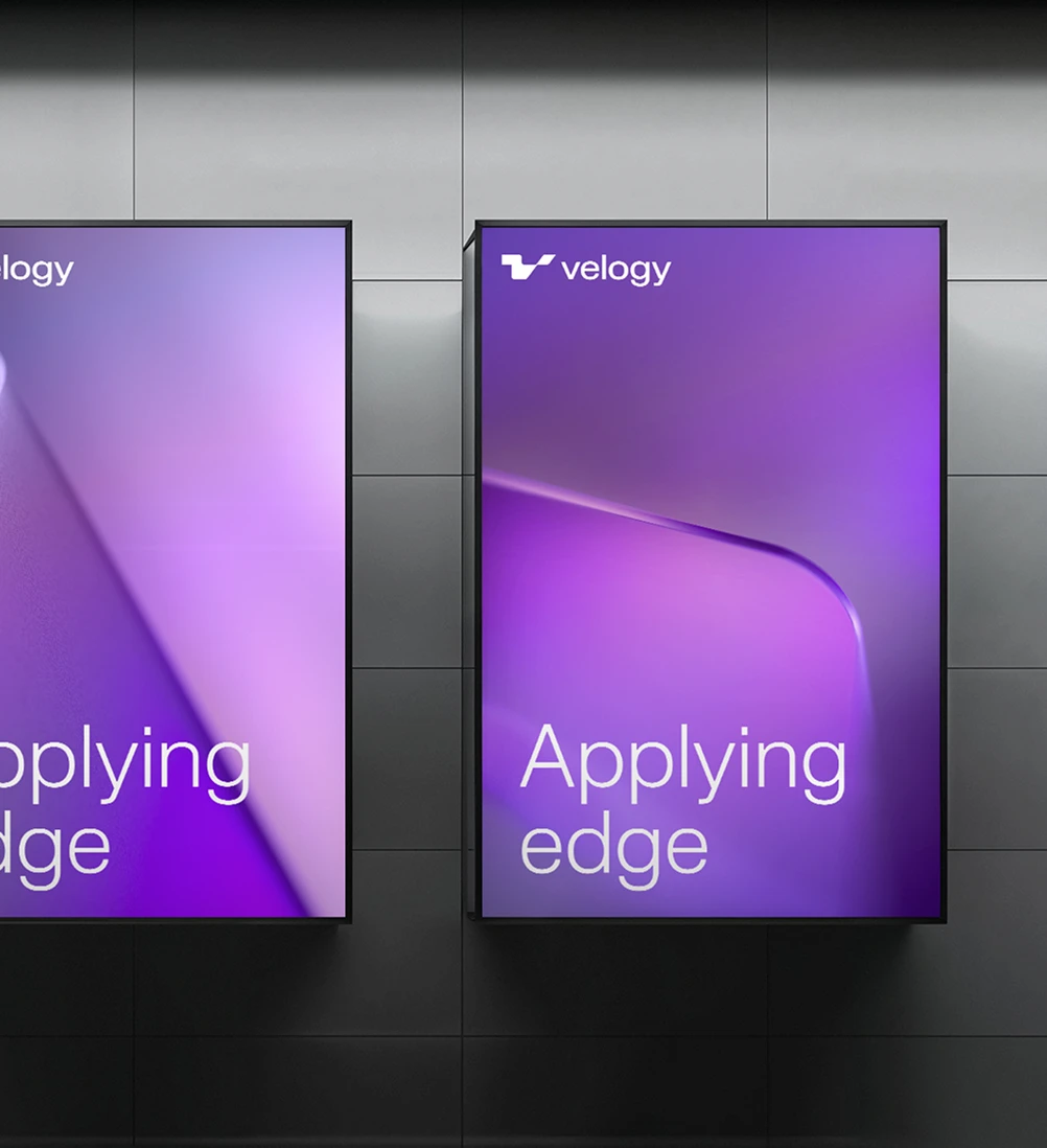 Two digital advertising screens displaying the white Velogy logo and “Applying edge” over abstract purple backgrounds.